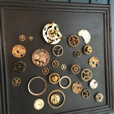 Wandpaneel met oude klokonderdelen